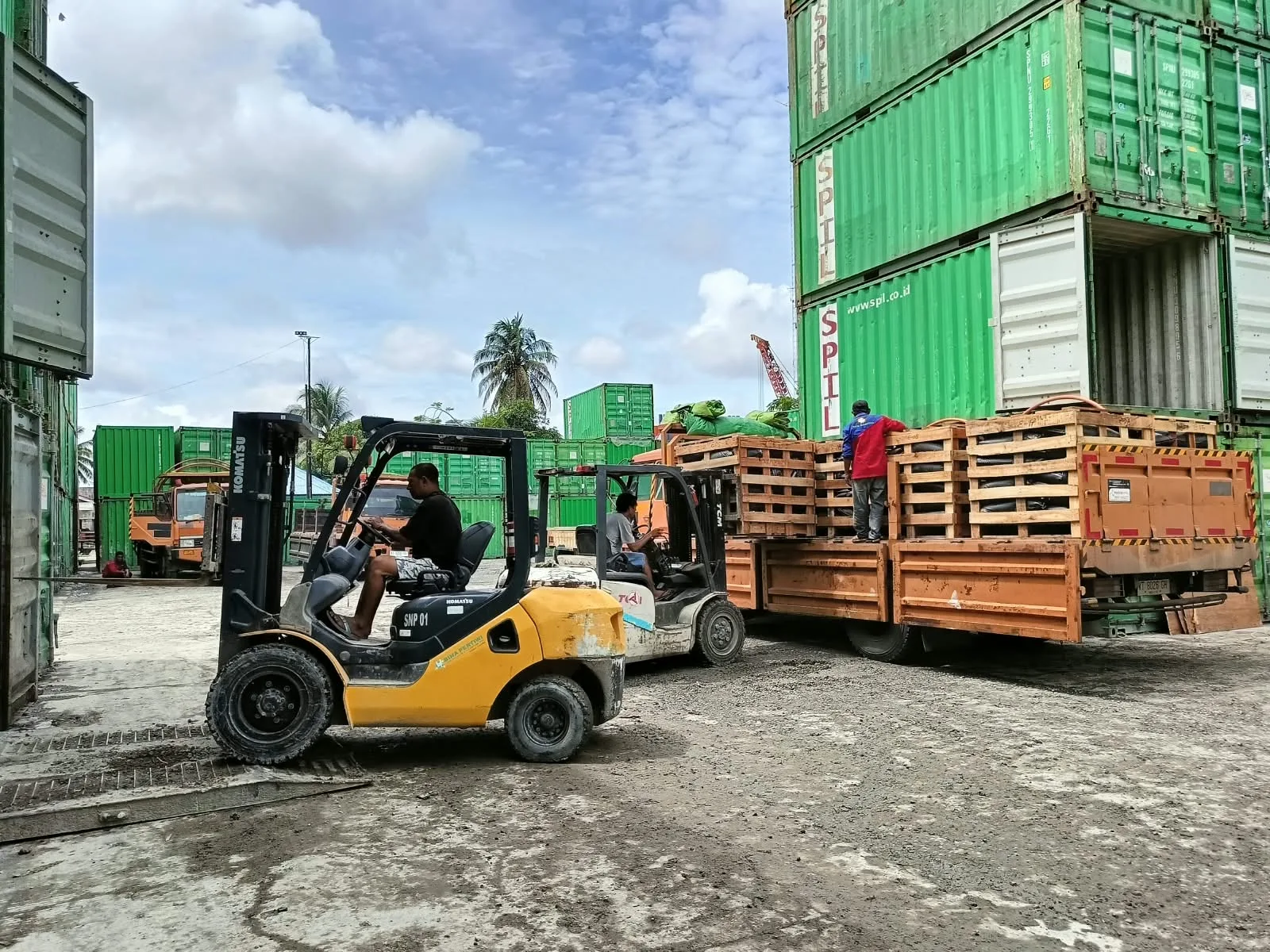 Kegiatan forklift dan truk dalam penanganan muatan.